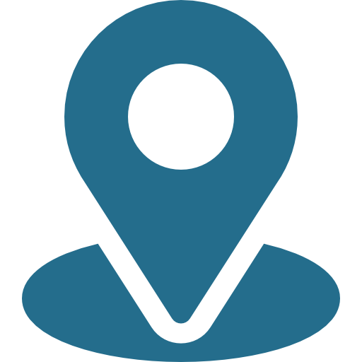 A location pin icon, typically used to indicate a place or point on a map. The pin is a solid teal color with a circular hole at the top, representing a geographical marker.
