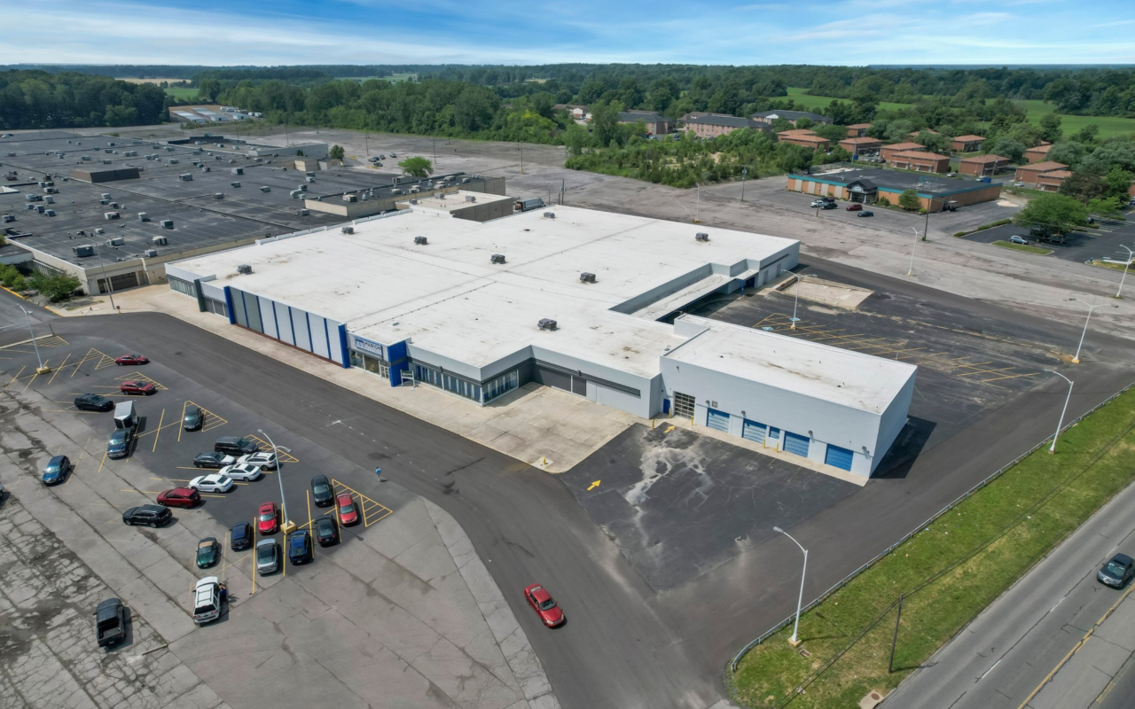 Aerial view of a large self-storage facility in Marion with a white roof, ample parking space, and surrounding greenery.